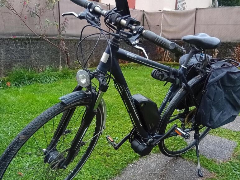 Vélo électrique noir sur pelouse.