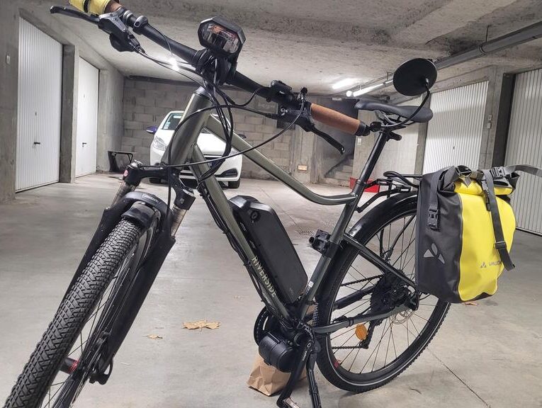 Vélo électrique avec sacoche jaune dans un garage.