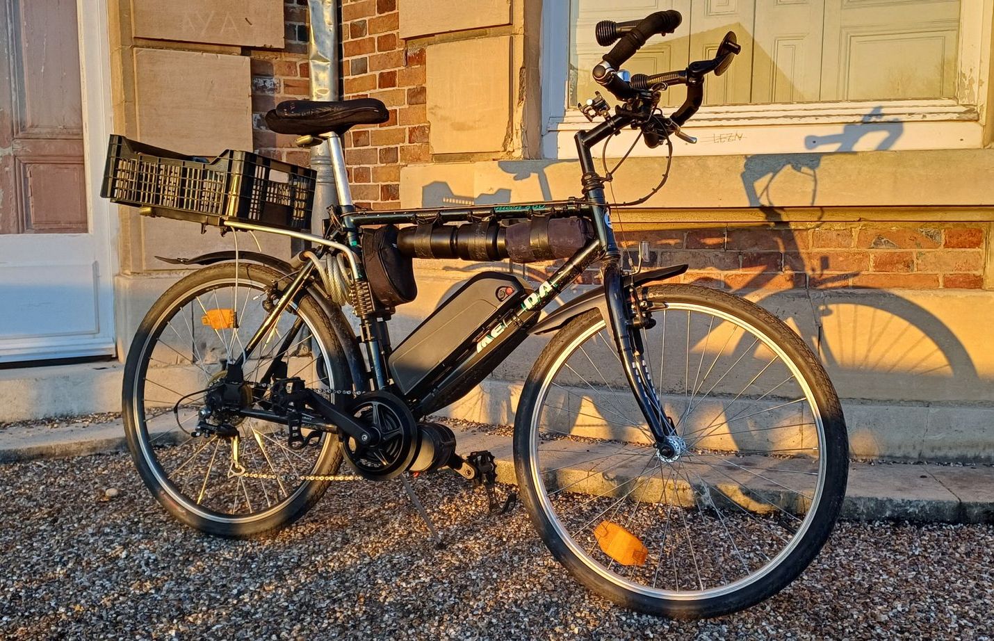 Vélo électrique stationné devant un mur en brique.