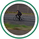Personne en vélo sous la pluie sur route.