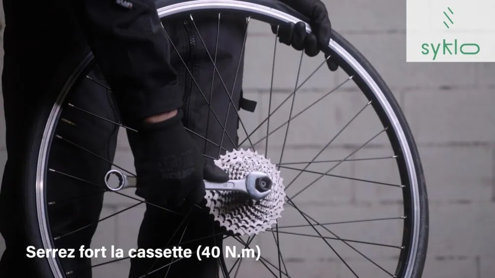 Hommes serrant la cassette d'une roue de vélo.