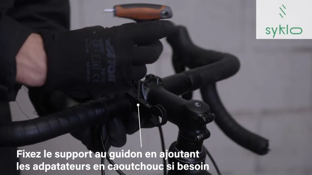 Hommes assemblant guidon de vélo avec outil.