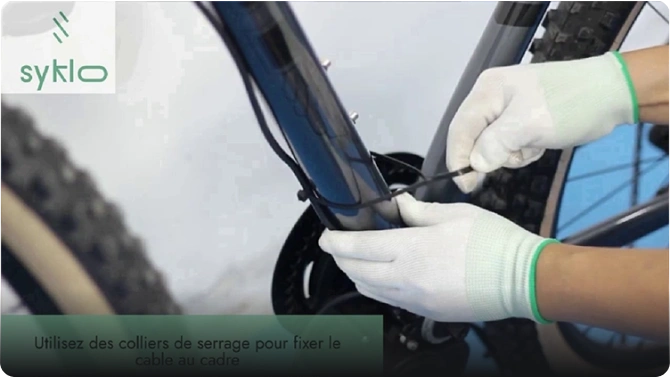 Fixation d'un câble sur un vélo avec collier.