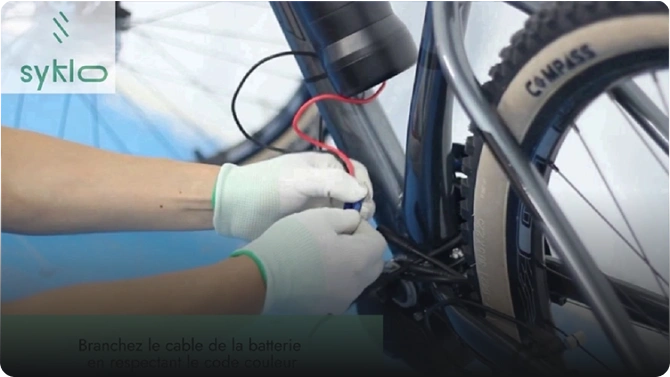 Branchement de batterie sur vélo électrique avec gants.